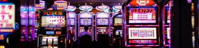 Casino Player Sitting on a Slot Machine at the back of the Floor